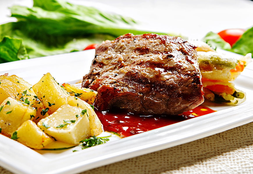 Grilled Beef Tenderloin with Potatoes and Salad on White Plate
