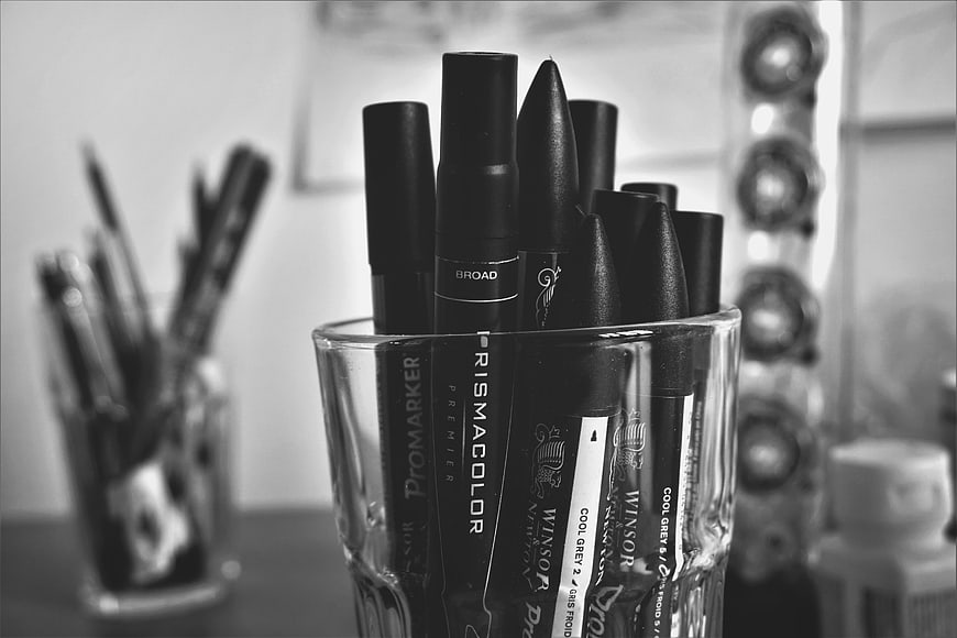 Black and white close-up of art markers in glass
