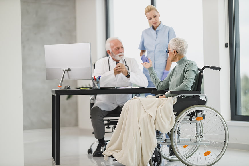 Senior Doctor Consulting Elderly Patient in Wheelchair