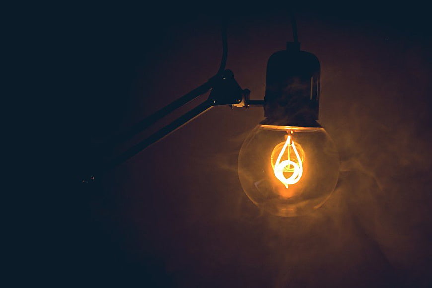Vintage Edison Light Bulb Hanging in Dark Room