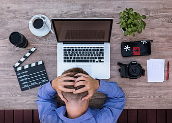 Stressed creative professional with hands on head at desk