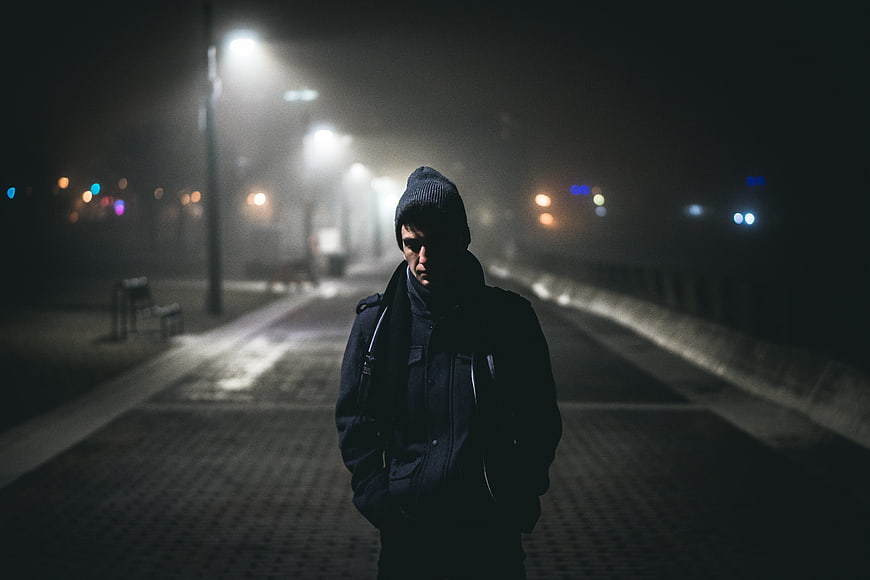 Man Walking Alone On Foggy Street At Night