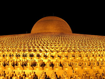 Golden Buddha statues arranged in rows before a large dome at night
