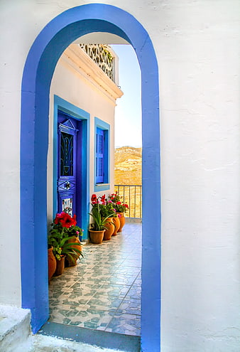 Blue Arched Doorway in White Greek House with Red Flowers