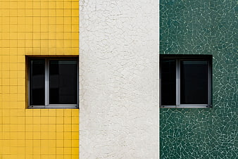 Colorful geometric building facade with yellow, white, and green tiles