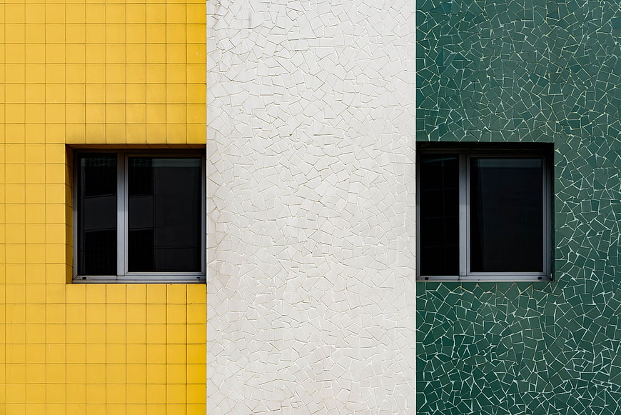 Colorful geometric building facade with yellow, white, and green tiles