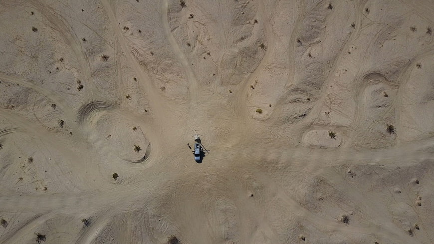 Aerial view of helicopter landing in desert sand