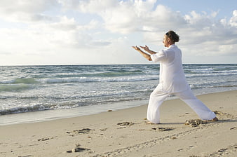 Man practicing Tai Chi on sandy beach