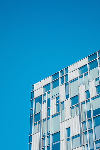 Modern white office building facade against clear blue sky