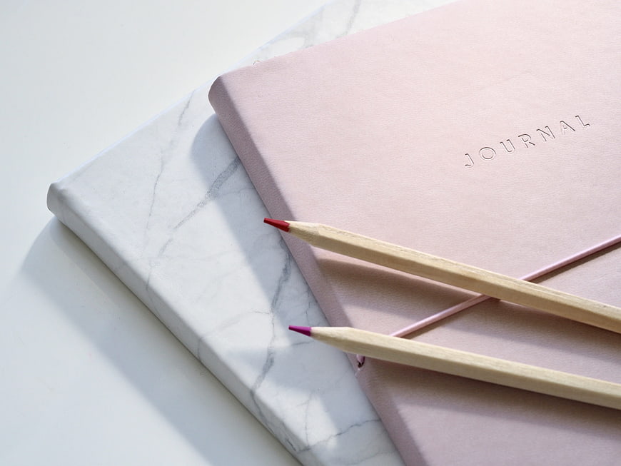 Pink Journal and Pencils on Marble Surface