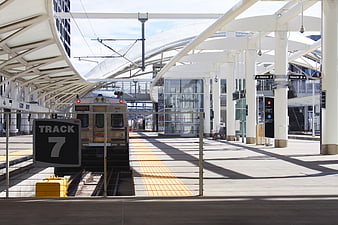 Modern Train Station Platform with Silver Commuter Train