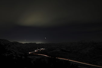 Nighttime light trails on winding mountain road