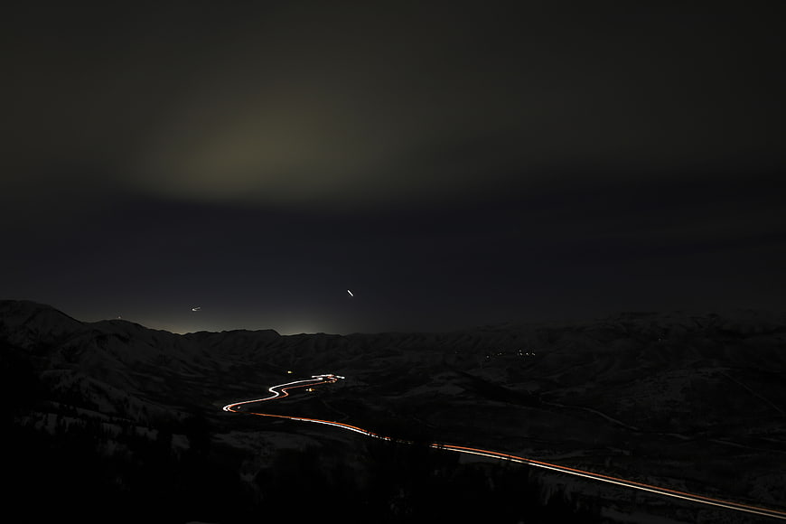 Nighttime light trails on winding mountain road