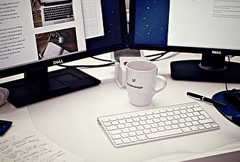 Modern office desk with dual monitors and branded coffee mug
