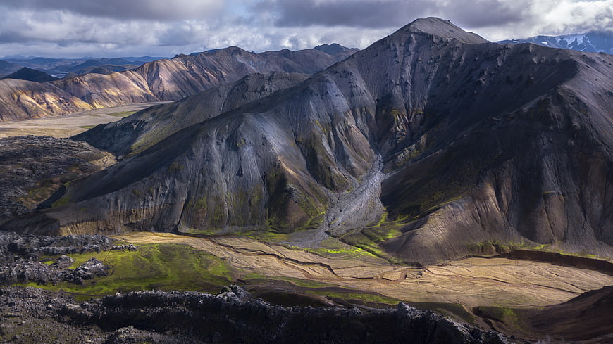 Dramatic volcanic mountains in Iceland with green moss and clouds