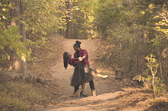African American couple dancing on a forest path in autumn