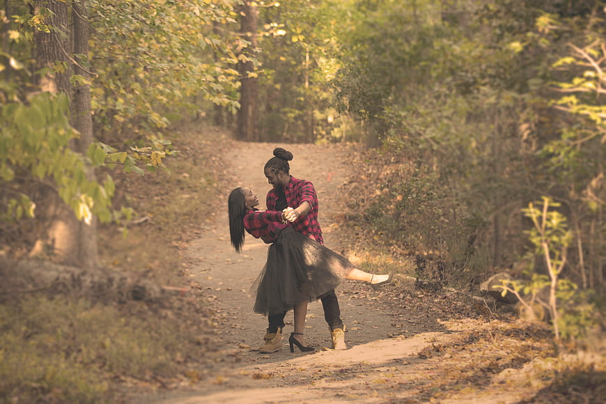 African American couple dancing on a forest path in autumn
