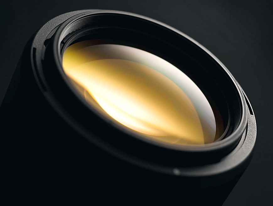 Close-up of camera lens with golden glass reflection