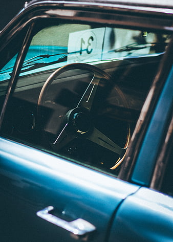Vintage blue car interior with wooden steering wheel