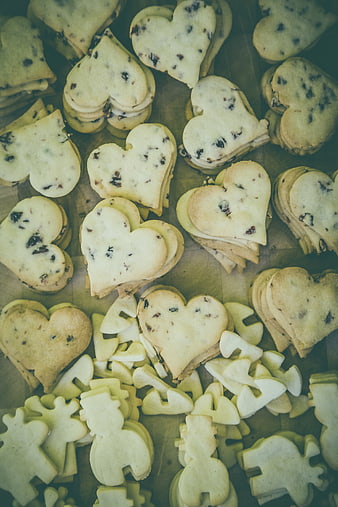 Heart-shaped cookies with chocolate chips on wooden surface