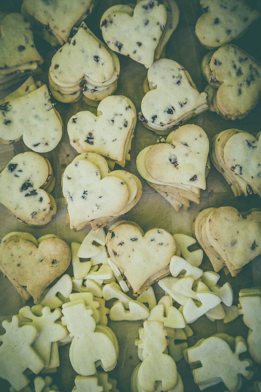 Heart-shaped cookies with chocolate chips on wooden surface