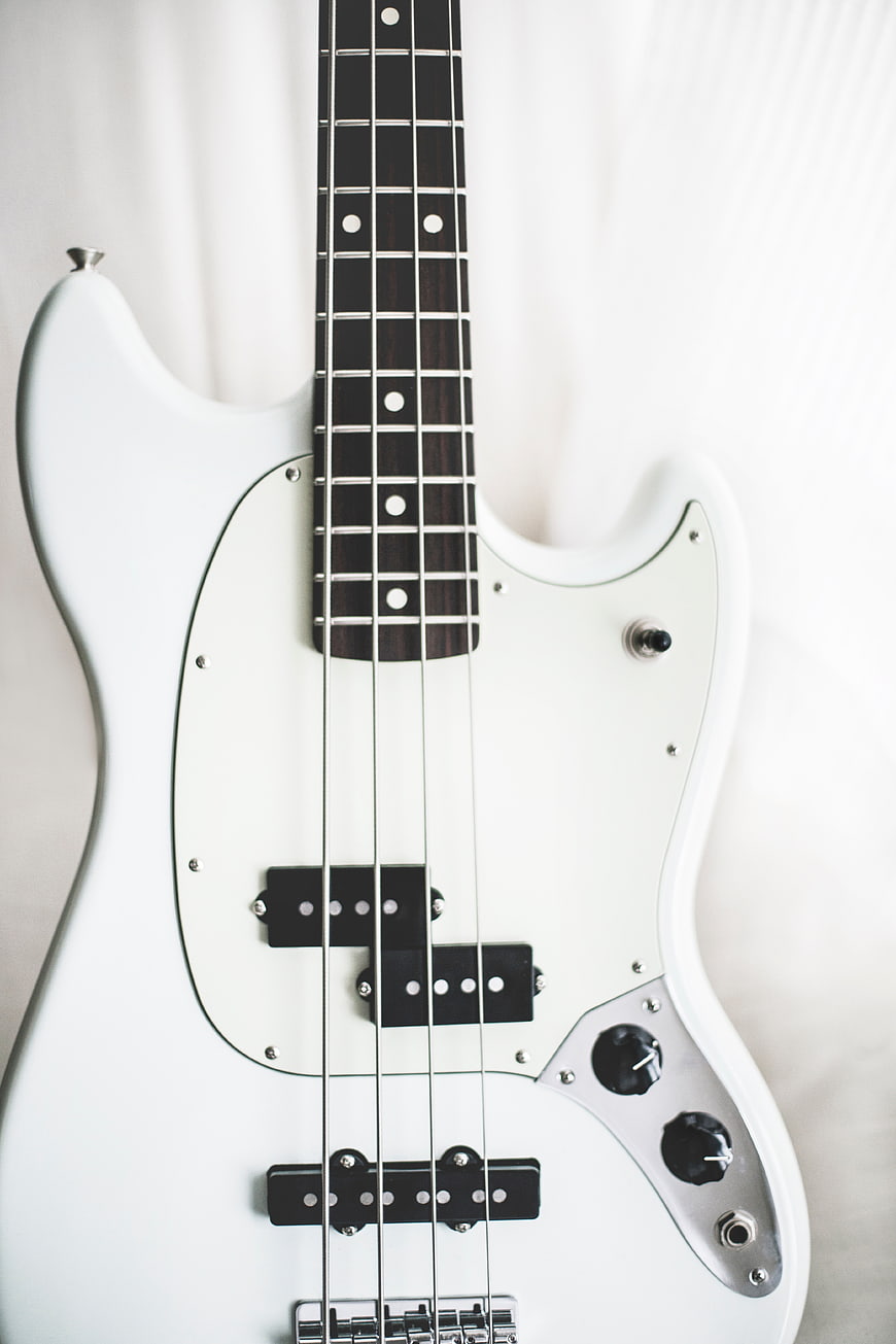 White electric bass guitar on white background