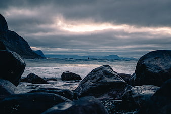 Dramatic moody seascape with crashing waves and dark rocks