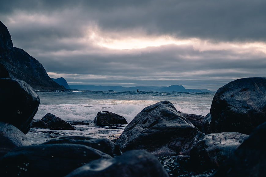 Dramatic moody seascape with crashing waves and dark rocks