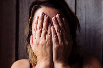 Woman Covering Face with Hands in Distress