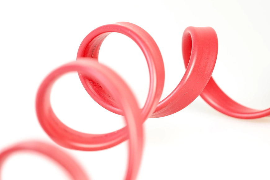 Coiled Red Telephone Cord on White Background