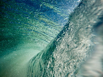Underwater view of a crashing ocean wave with bubbles