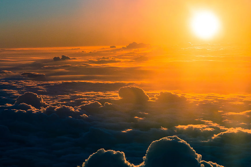 Golden sunset above sea of clouds aerial view