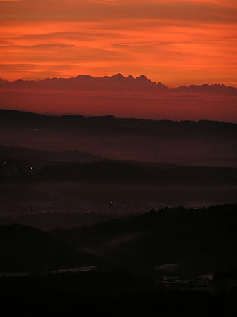 Dramatic Red Sunset Over Silhouetted Mountain Ranges