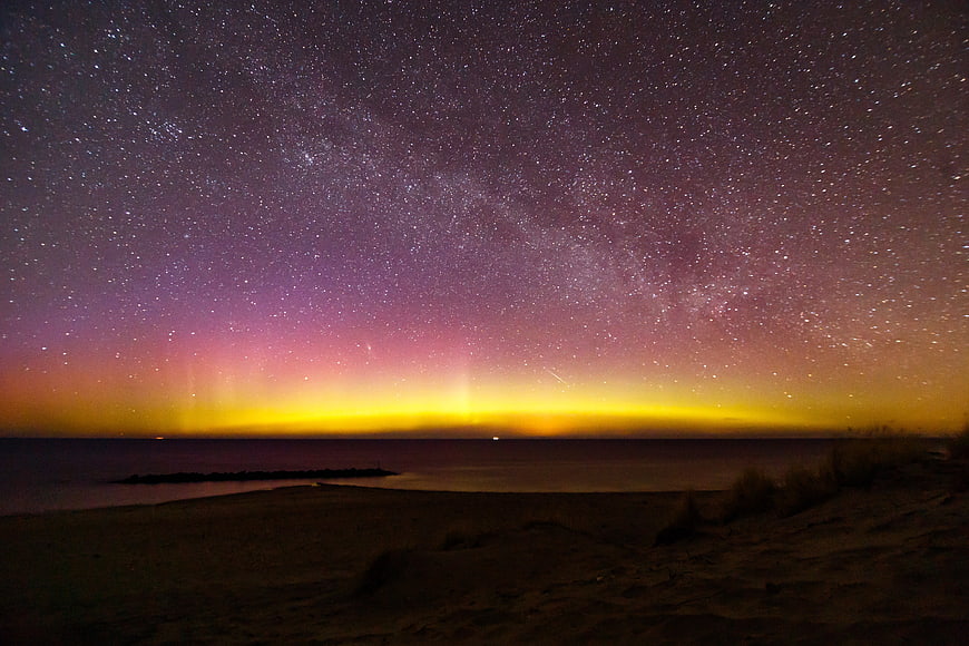 Milky Way Galaxy and Aurora Borealis Over a Dark Beach at Night