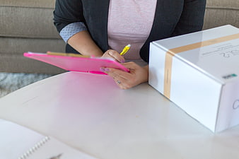 Woman signing for package delivery with clipboard