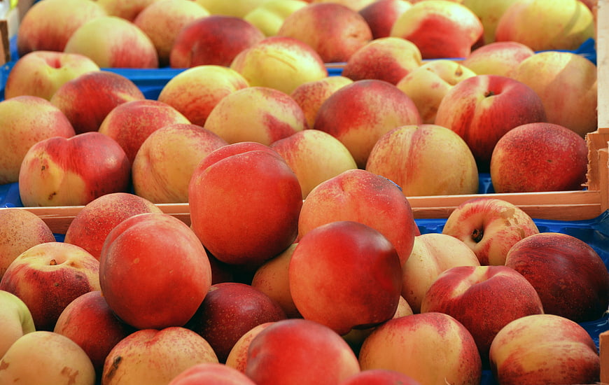Fresh ripe peaches in wooden crates at a market