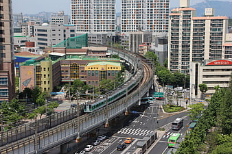 Elevated subway train curving through Seoul cityscape