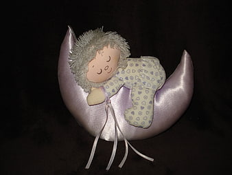 Sleeping baby doll on purple crescent moon plush toy