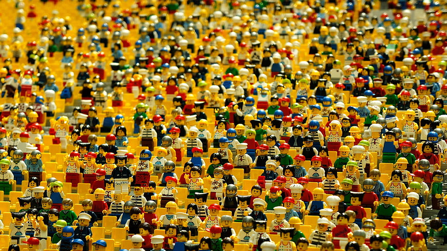 Large crowd of colorful Lego minifigures sitting in rows