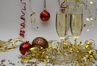 Champagne Glasses with Christmas Ornaments and Gold Streamers
