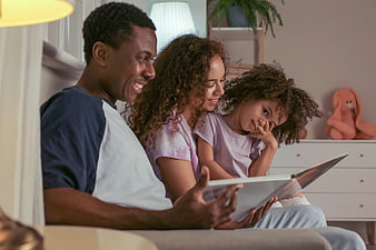 Happy African American Family Reading Book Together at Home