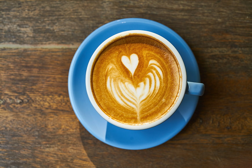 Top View Cappuccino with Heart Latte Art on Blue Saucer