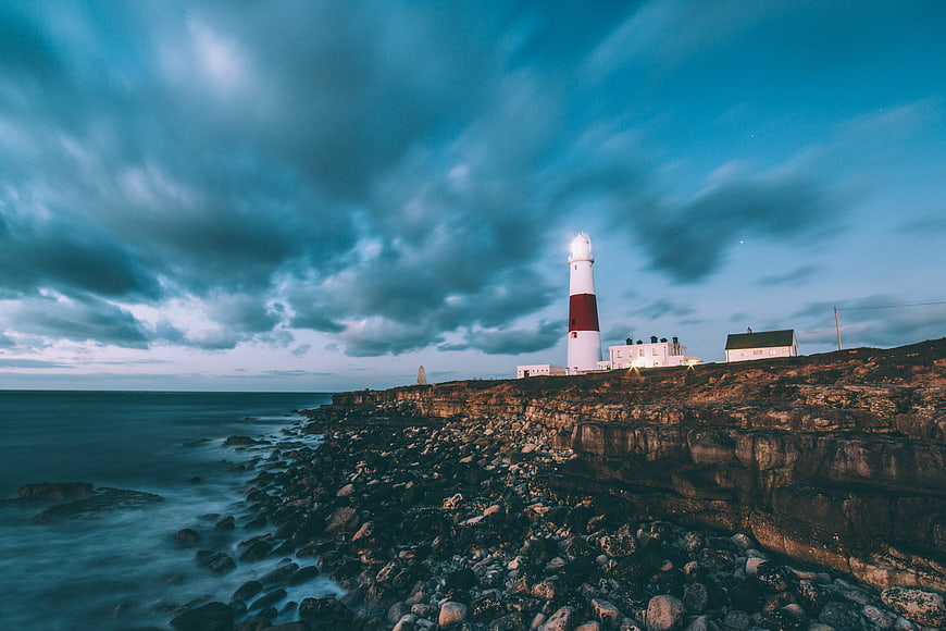 Dramatic Lighthouse on Rocky Coastline at Dusk