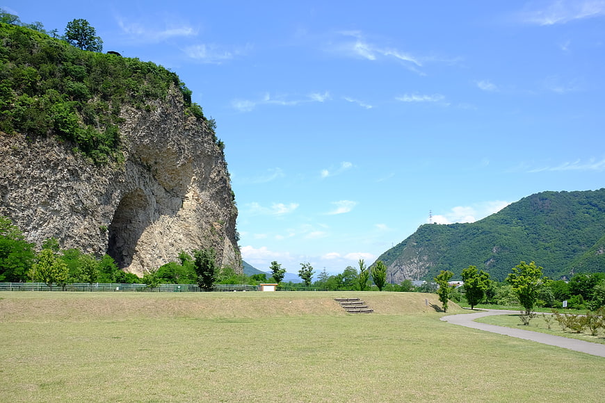Grassy park with large cliff face and blue sky