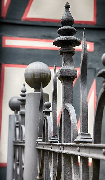 Close-up of ornate wrought iron fence with blurred background