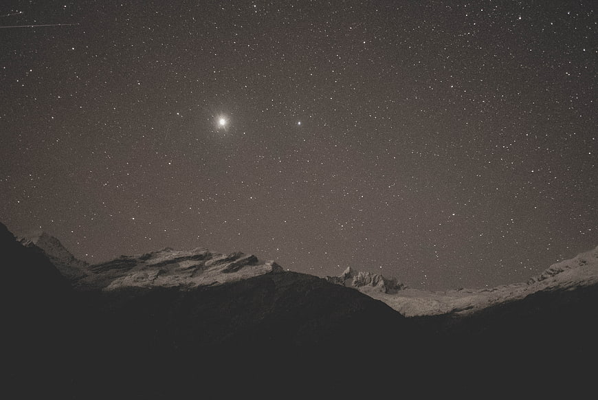 Snowy Mountain Peaks Under Starry Night Sky