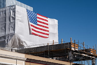 American Flag on Construction Site Against Blue Sky