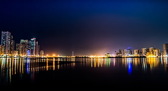 Night Skyline of Modern City with Water Reflections