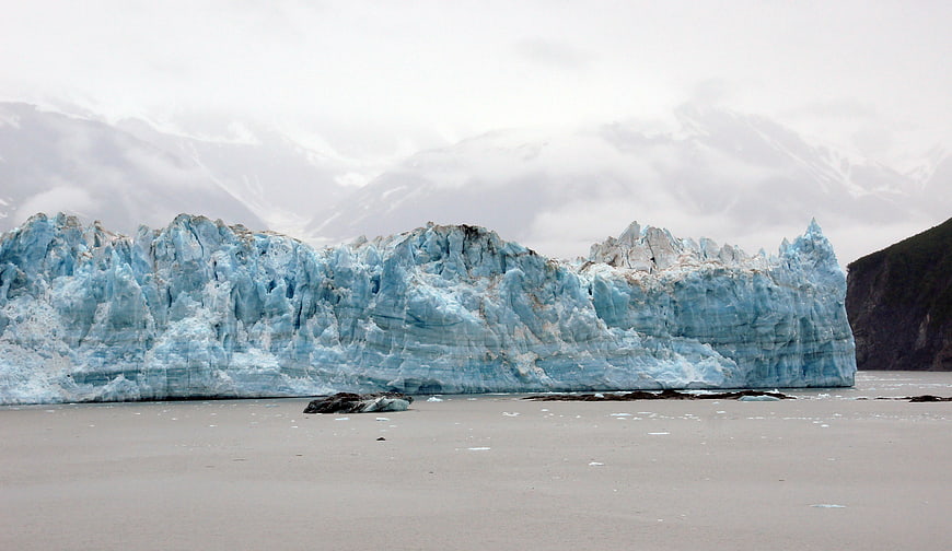Massive Blue Glacier Face in Glacial Lake with Mountains
