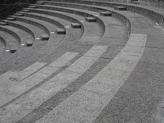 Curved concrete amphitheater seating with stone steps